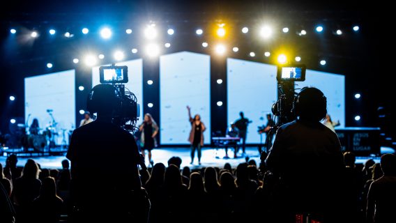 Cover image shows a person singing on a stage and a camera crew filming the stage.