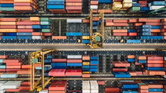 Image shows shipping containers in a container port