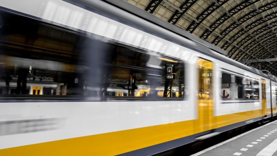 Image shows a fast-moving train passing a platform.
