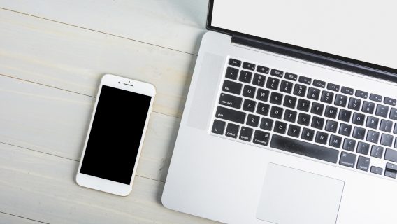 Image shows a laptop and mobile phone